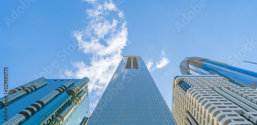Canvas Print Looking up to high-rise office buildings, skyscrapers, architectures in financial district with blue sky