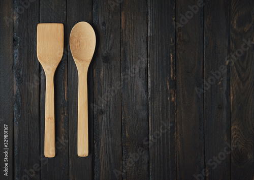 Wooden kitchen appliances on a black wooden background.