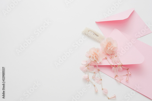 Wedding text background, white, decorated with pink invitation envelopes, top view, with copy space. The concept of a wedding date or a gentle background for the bride.