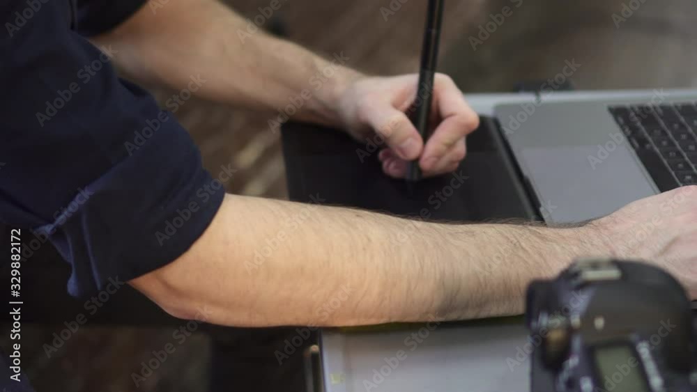 Hands of a male photographer, designer use a graphics tablet. Close up, slider shot. Hands of a male photographer, designer use a graphics tablet. Close up, slider shot.