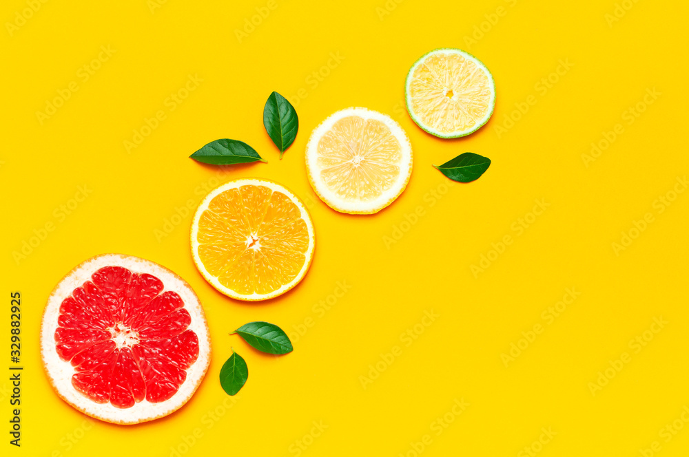 Flat lay composition with slices of fresh lemon orange grapefruit lime green leaves on yellow background top view copy space. Citrus Juice Concept, Vitamin C, Fruits. Creative summer background Flat lay composition with slices of fresh lemon orange grapefruit lime green leaves on yellow background top view copy space. Citrus Juice Concept, Vitamin C, Fruits. Creative summer background