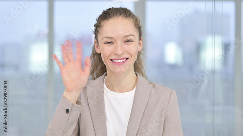 Portrait of Young Businesswoman Waving at Camera © stockbakers