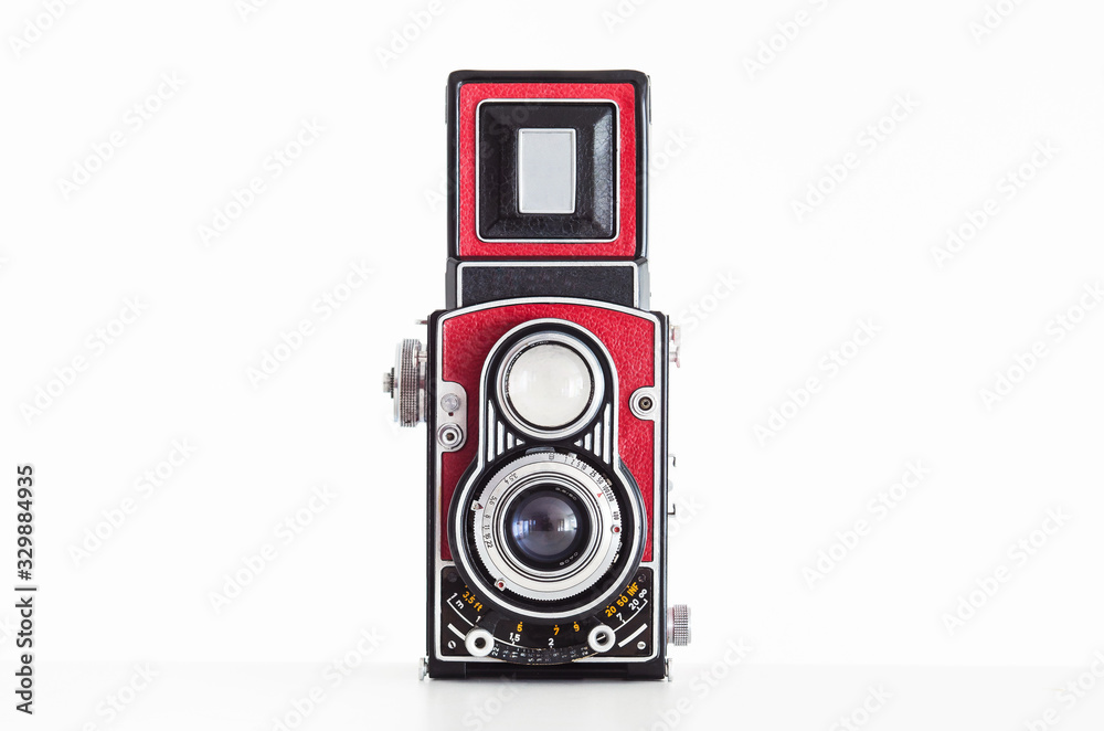 Old vintage medium square format twin lens reflex camera wrapped in red leatherette front view isolated on white background
