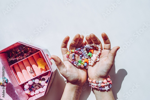 bead bracelets. casket with beads in hands. decorations. bijouterie. hobbies of girls. rings. background
