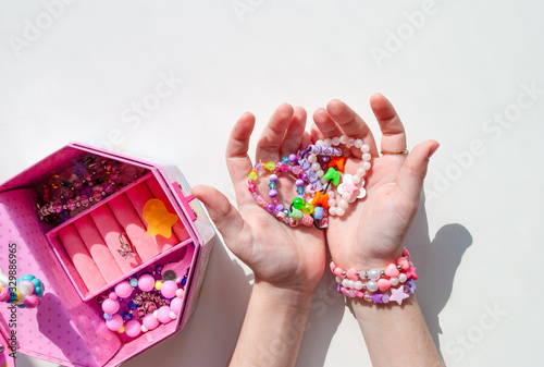bead bracelets. casket with beads in hands. decorations. bijouterie. hobbies of girls. rings. background