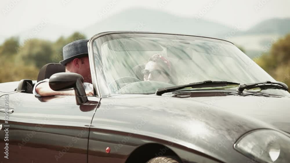 Couple get into convertible on sunny day and prepare for road-trip. Woman driving. Transportation and relationships concept Couple get into convertible on sunny day and prepare for road-trip. Woman driving. Transportation and relationships concept