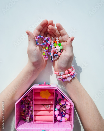 bead bracelets. casket with beads in hands. decorations. bijouterie. hobbies of girls. rings. background