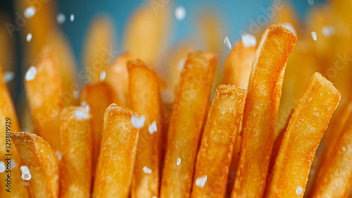 Freeze Motion Detail Shot of adding Salt on Fresh French Fries