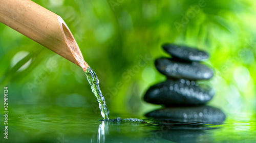 Photography Macro shot of leaking water stream from bamboo, spa and wellness concept