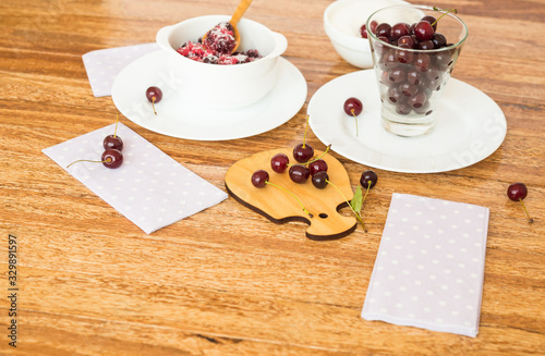 Berries. Cherry with sugar on a small wooden cutting board