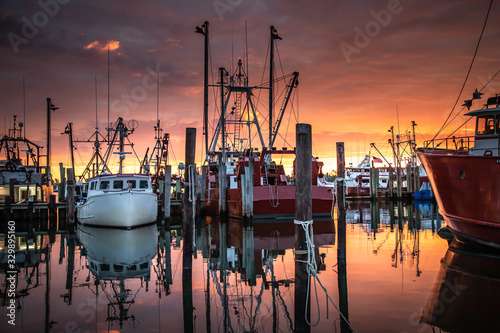 Spectacular sunrise over a fishing fleet photo