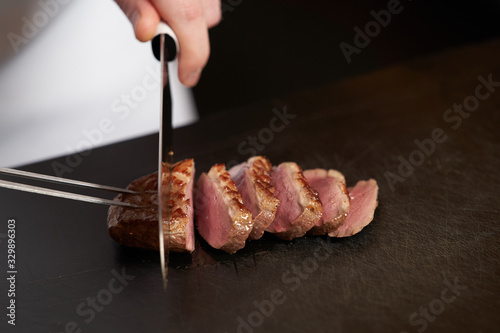 Chef dicing duck fillet. Chef cutting poultry meat