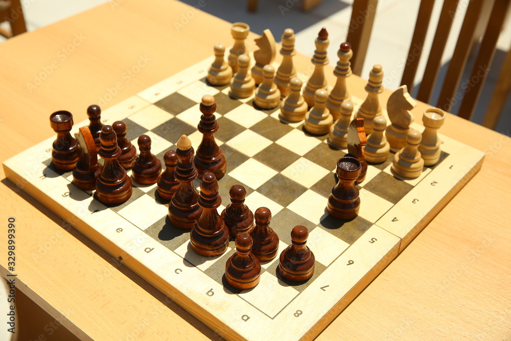 Yellow and brown photo with a picture of a chess Board pieces, Wooden pieces on a chess Board and emtye table . How to play wooden chess game. Chess board with yellow and brown figures . Yellow and brown photo with a picture of a chess Board pieces, Wooden pieces on a chess Board and emtye table . How to play wooden chess game. Chess board with yellow and brown figures .