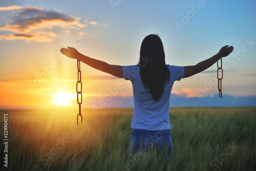 Woman feeling free in a beautiful natural setting, in what field at sunset. Free from chains photo