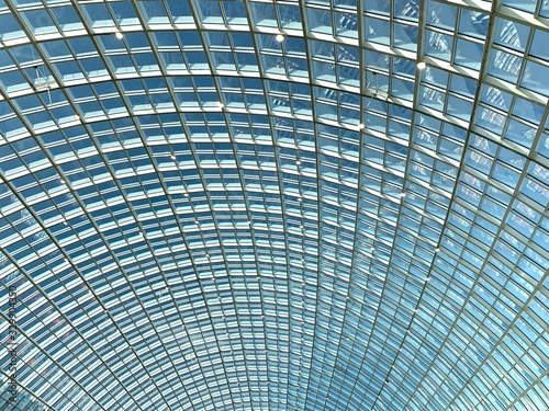 Glass roof, texture, view of the blue sky.