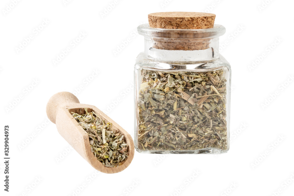 wormwood herb or in latin Absinthii herba herb in a glass jar and wooden scoop isolated on white background. medicinal healing herbs. herbal medicine. alternative medicine