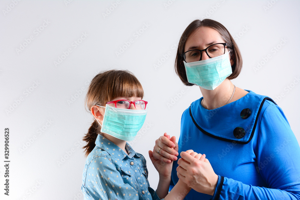 Mother and daughter Wearing Medical Mask Concept. Girl child in surgical mask with her mother. On a white background, copy space. minimize risk of viral transmission