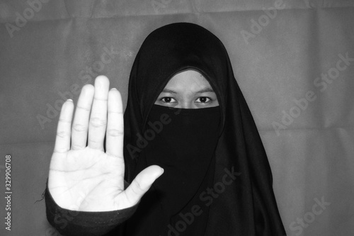 Close up view of Pretty lady woman girl wear hijab jilbab niqab kerudung niqaab scarf cover face and only show visible look of her beauty eyes. Fit for put design life image. Black white  with grain t photo