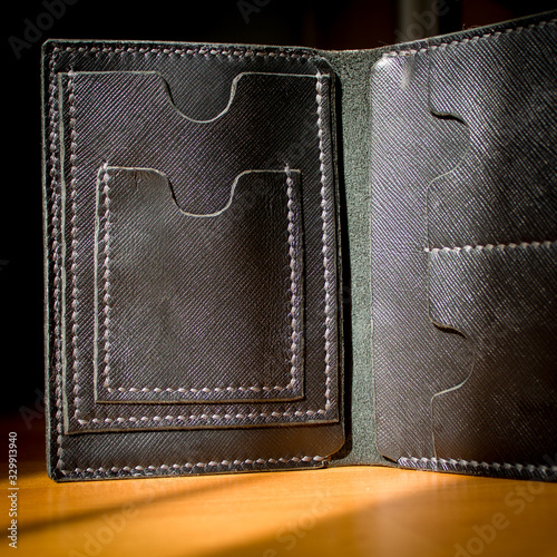 handmade black leather wallet located on a wooden board