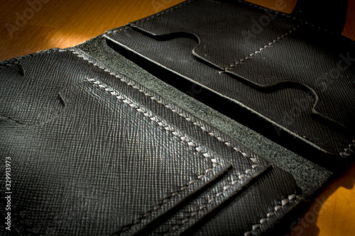 handmade black leather wallet located on a wooden board