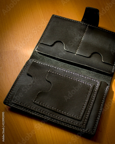 handmade black leather wallet located on a wooden board