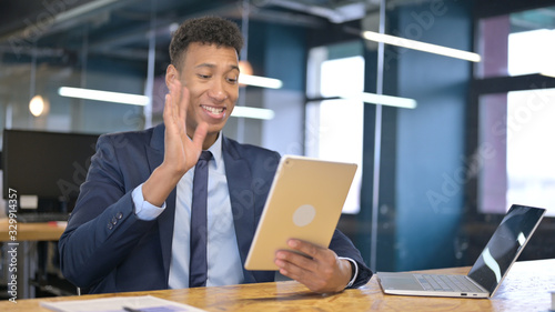 Young Businessman doing Video Chat on Tablet in Office