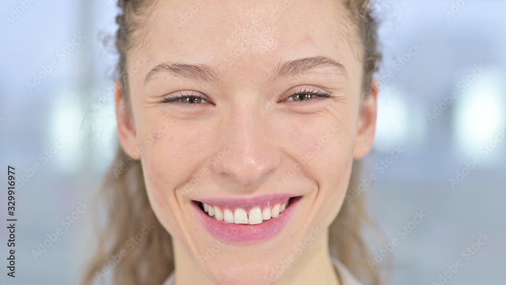 Close Up of Cheerful Young Woman Smiling at Camera