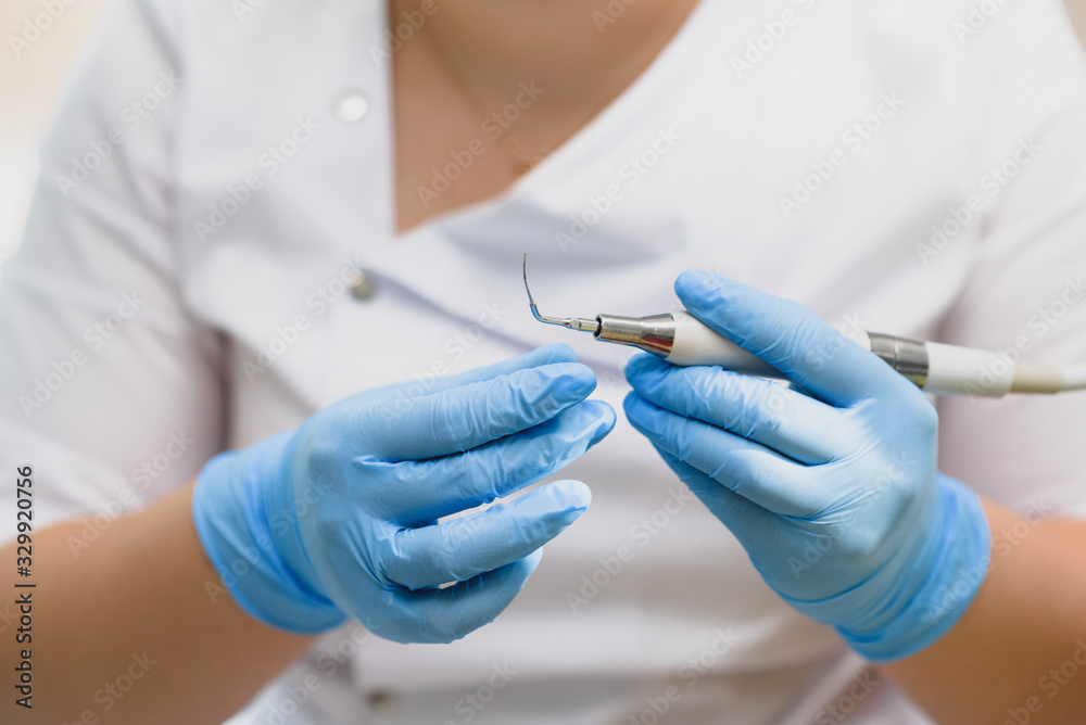Dentist and his assistant show different medical instruments. female dentist doctor holding tools in his hands Dentist and his assistant show different medical instruments. female dentist doctor holding tools in his hands