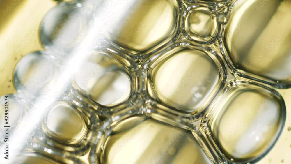 Close up of abstract oil bubbles inside bottles. Cosmetic gel or serum with pipette inside. Healthcare golden liquid. 4K Close up of abstract oil bubbles inside bottles. Cosmetic gel or serum with pipette inside. Healthcare golden liquid. 4K