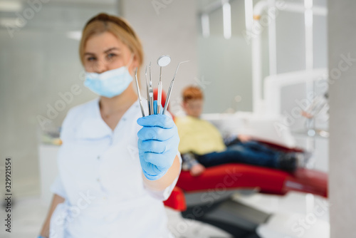 Portrait of a dentist holding dental instruments in his hands in the clinic close-up