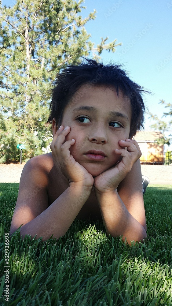 Thoughtful Shirtless Boy Lying Down On Grassy Field Stock Photo | Adobe ...