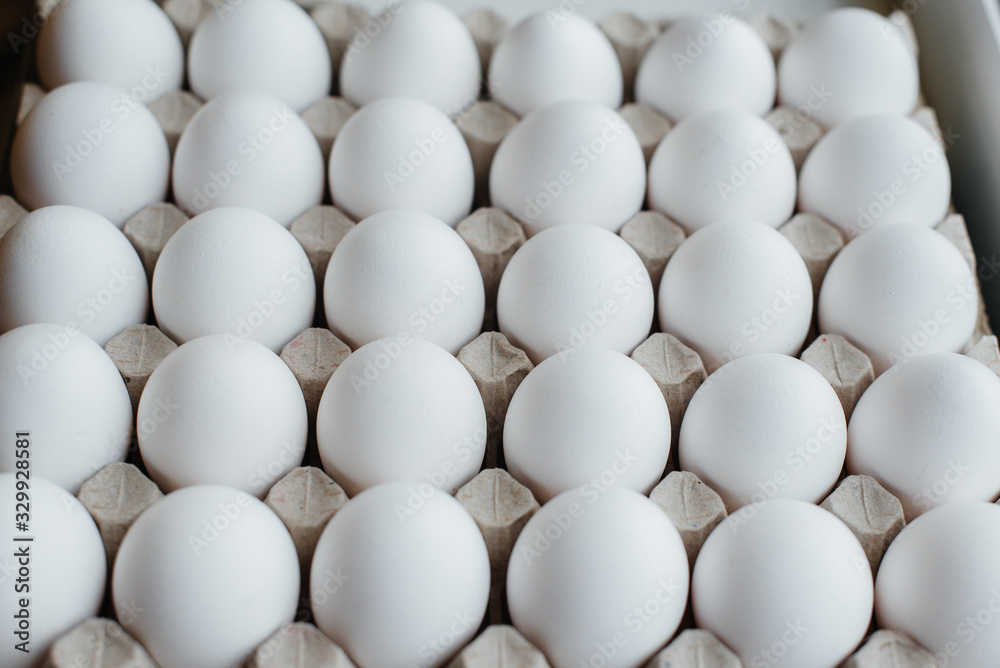 Tray of white fresh eggs close-up on a cardboard form. Agricultural industry Tray of white fresh eggs close-up on a cardboard form. Agricultural industry