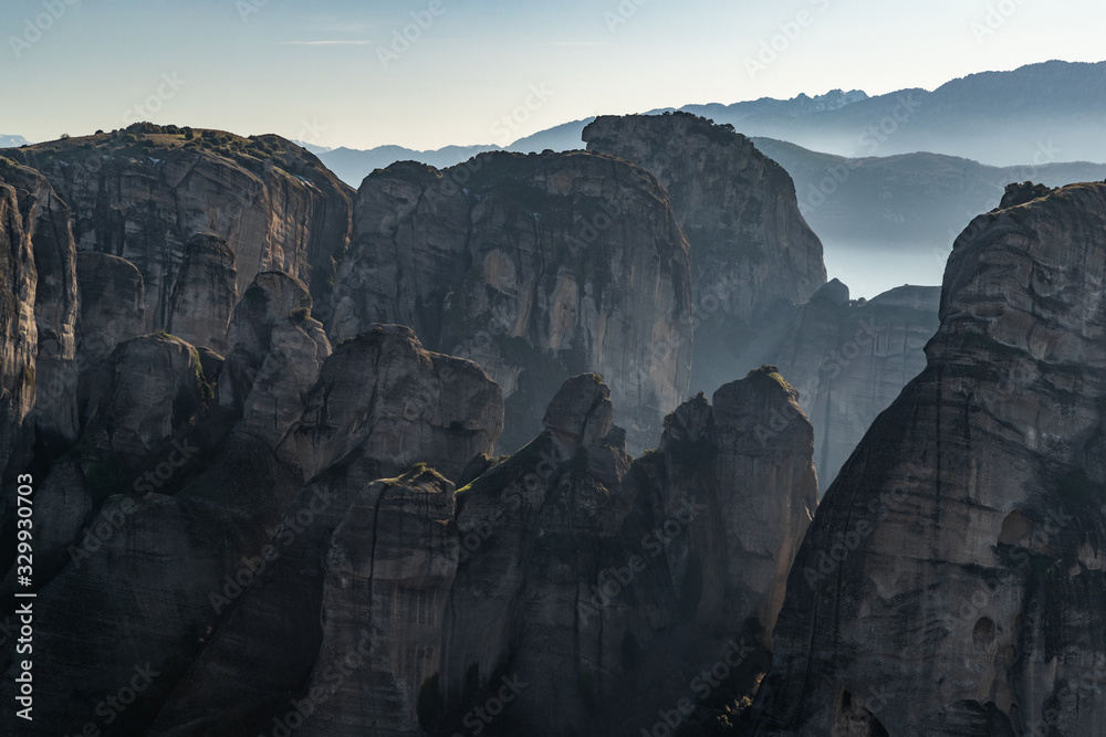 Aerial view of Unesco monument Meteora, the mountains, the landmark of Greek, sunny weather, fog, haze over a valley