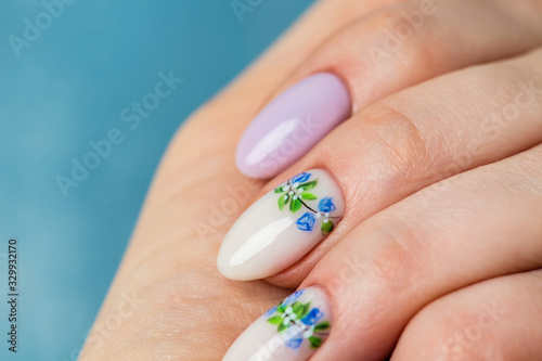 Nails Design. Hands With Bright lilac and White Manicure with Spring flowers. Close Up Of Female Hands. Art Nail.