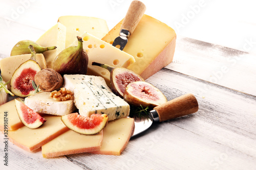 Cheese plate served with figs, various cheese on a rustic table