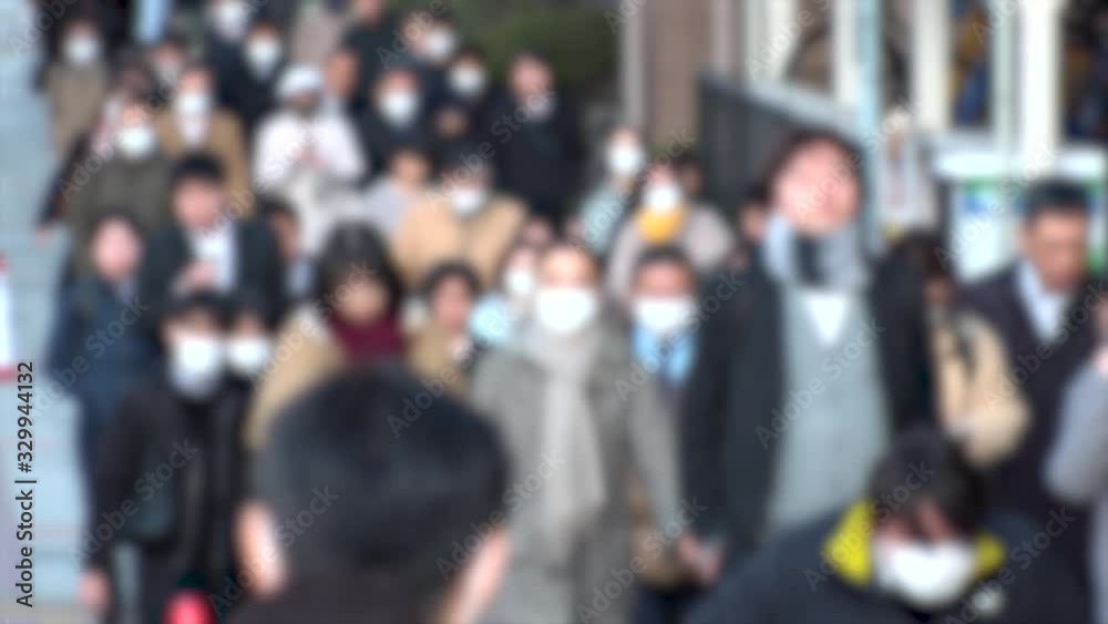 TOKYO, JAPAN -MARCH 2020 : Crowd of people walking down the street in morning rush hour. Commuters going to work. People wearing mask to protect from Coronavirus(COVID-19) or cold. Blurred slow motion TOKYO, JAPAN -MARCH 2020 : Crowd of people walking down the street in morning rush hour. Commuters going to work. People wearing mask to protect from Coronavirus(COVID-19) or cold. Blurred slow motion