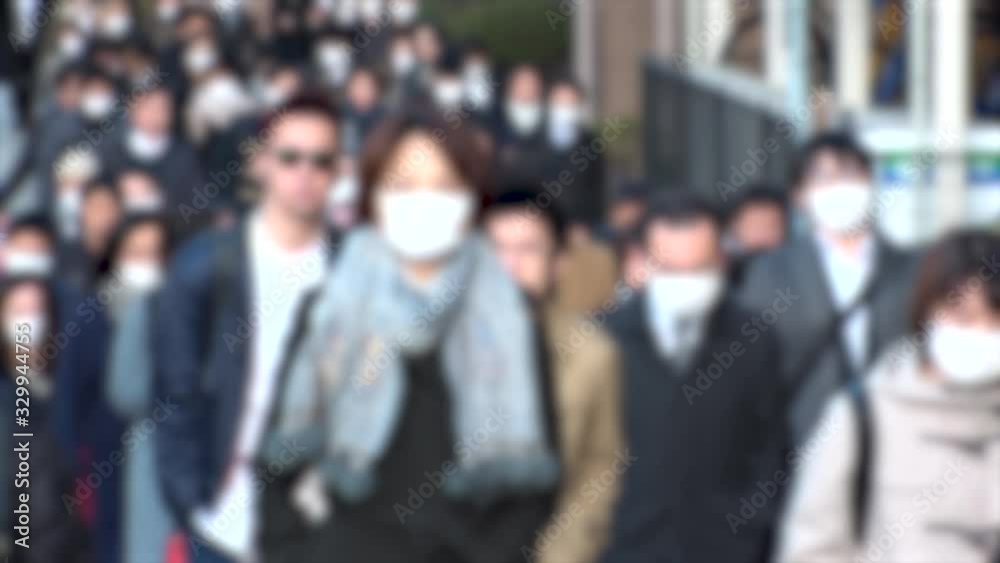 TOKYO, JAPAN -MARCH 2020 : Crowd of people walking down the street in morning rush hour. Commuters going to work. People wearing mask to protect from Coronavirus(COVID-19) or cold. Blurred slow motion TOKYO, JAPAN -MARCH 2020 : Crowd of people walking down the street in morning rush hour. Commuters going to work. People wearing mask to protect from Coronavirus(COVID-19) or cold. Blurred slow motion