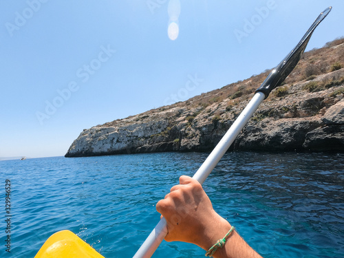 Tourists practicing kayaking on one of the beaches on the island of Gozo, Malta. People enjoying summer on the beach.