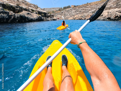 Tourists practicing kayaking on one of the beaches on the island of Gozo, Malta. People enjoying summer on the beach.