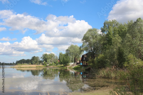 scenic view lake with grass overgrown swamp house on the beach in summer