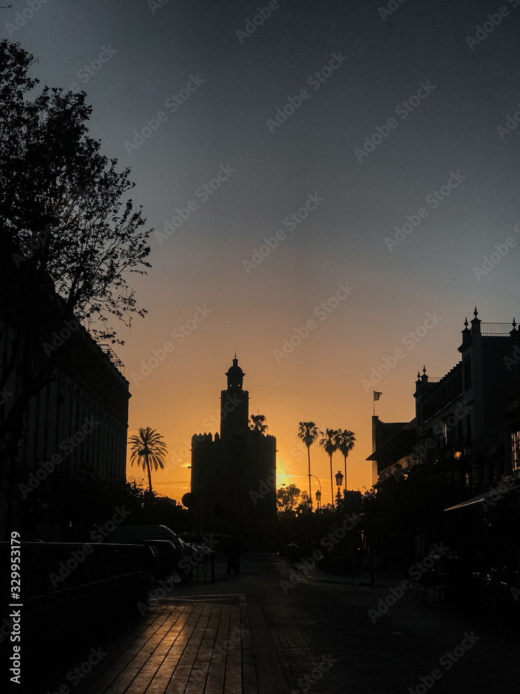 Urban view of Seville in an orange sunset. Gold tower.