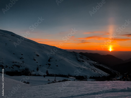 Beautiful view of snowy mountains, beautiful European winter mountains in Sierra Nevada, slope for cross-country skiers in the sunset landscape.