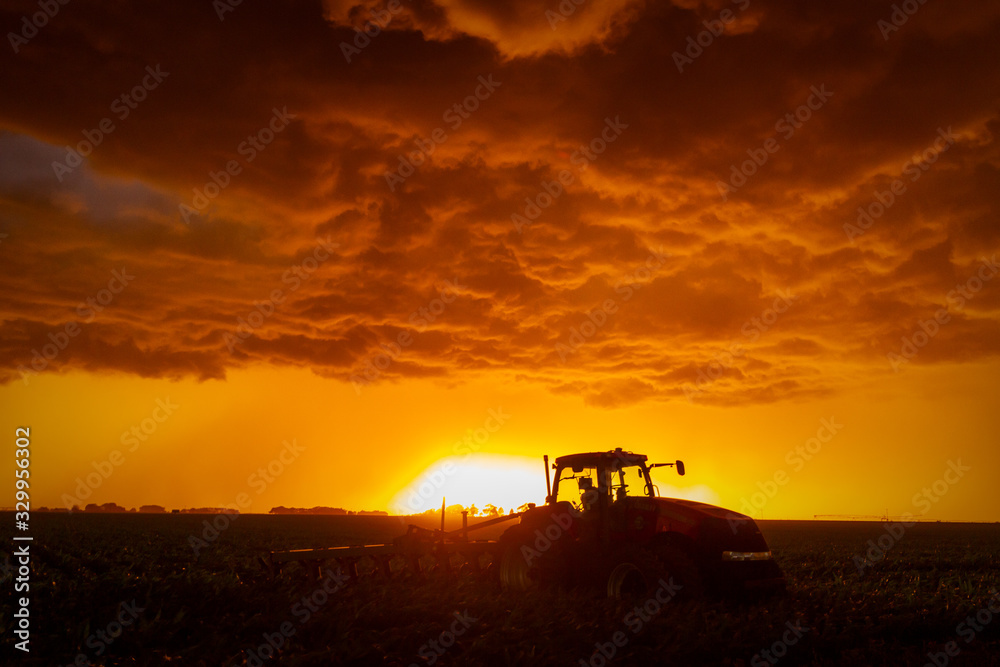 farm equipment against a stormy sunset in nebraska