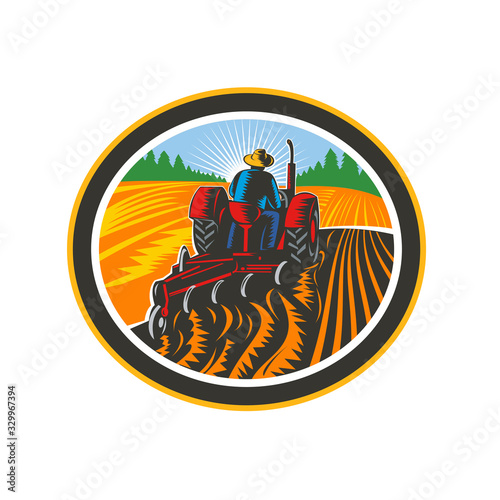 Retro illustration of a farmer worker driving a vintage tractor plowing farm or field viewed from rear set inside oval shape done in woodcut style on isolated background in full color.