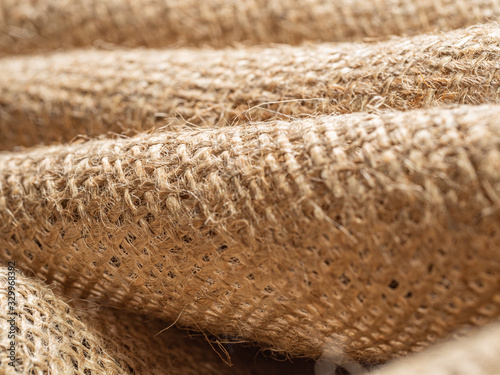 Texture of brown baline, close up view. Crumpled burlap fabric, an abstract background. Selective soft focus. Blurred background