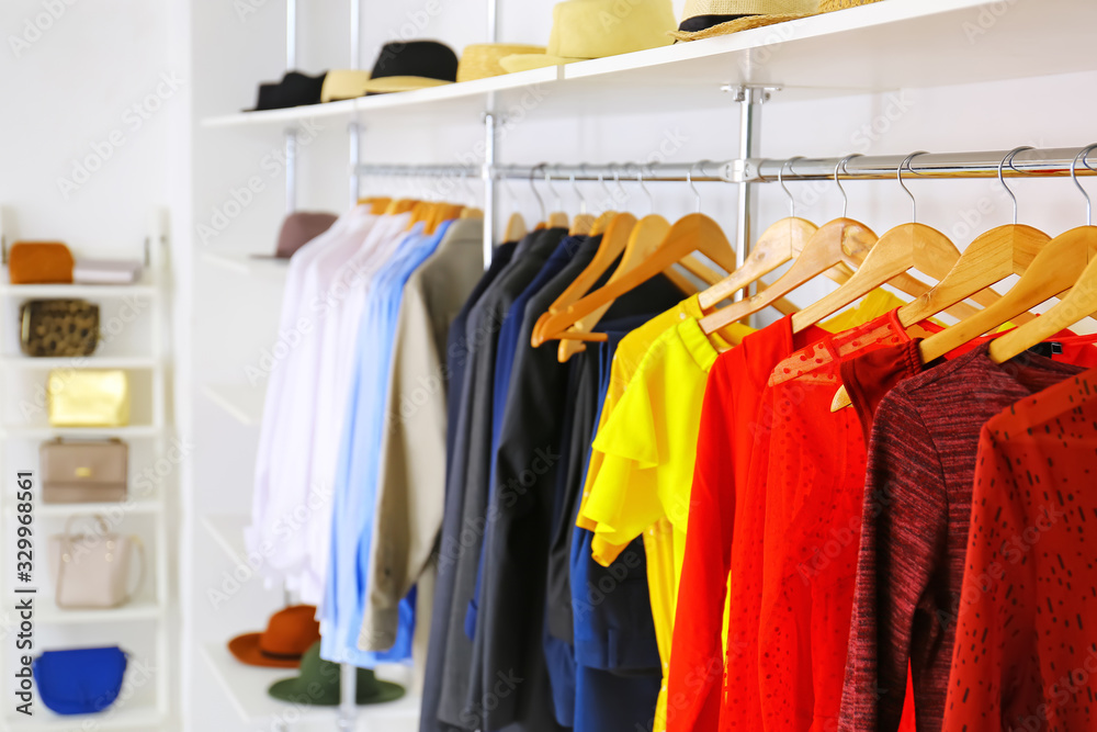 Fototapeta premium Stylish clothes on hangers in modern store