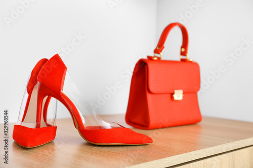 Stylish bag with high-heels on shelf in modern store