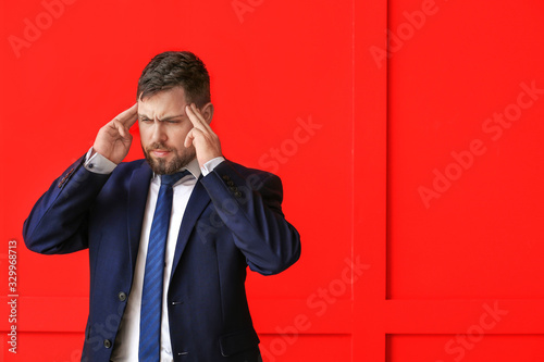 Young worried businessman on color background photo