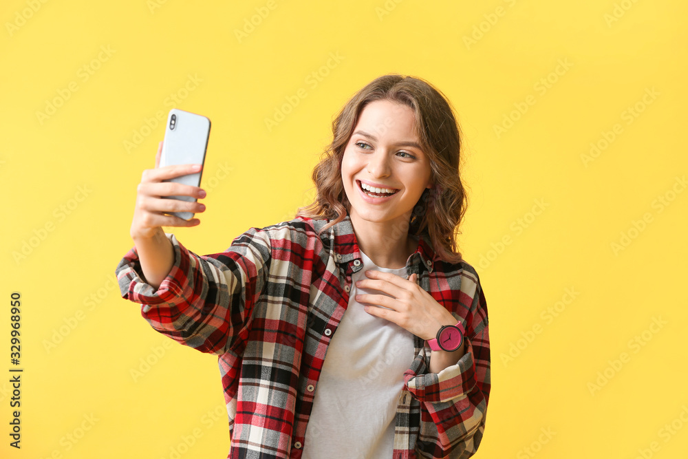 Young woman taking selfie on color background Young woman taking selfie on color background