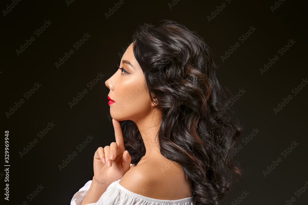 Young Asian woman with beautiful hair on dark background Young Asian woman with beautiful hair on dark background